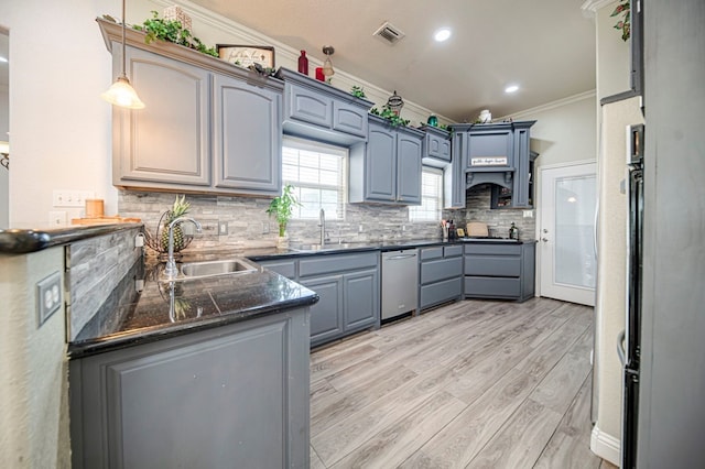 kitchen with decorative light fixtures, sink, light hardwood / wood-style flooring, and crown molding