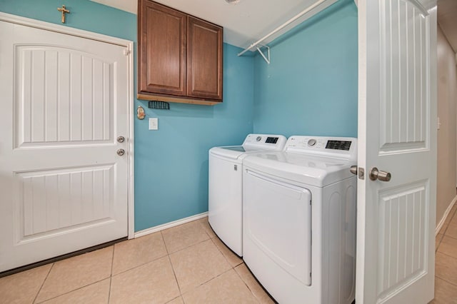 washroom featuring cabinets, light tile patterned floors, and separate washer and dryer