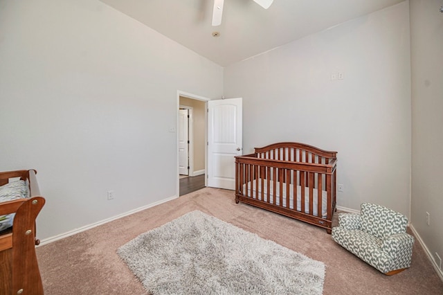 carpeted bedroom featuring ceiling fan, a nursery area, and high vaulted ceiling