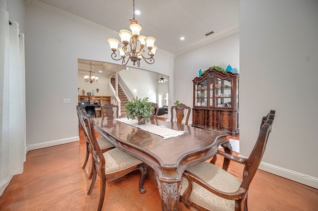 dining area with light wood-type flooring, ceiling fan with notable chandelier, and crown molding