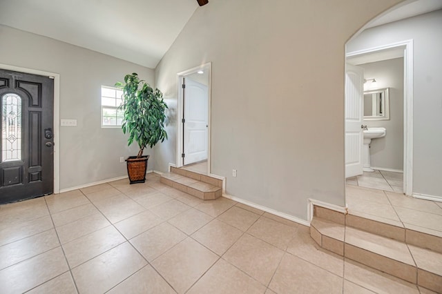 tiled entryway featuring vaulted ceiling