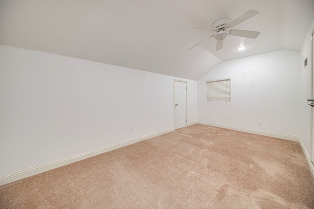 carpeted spare room with ceiling fan and vaulted ceiling