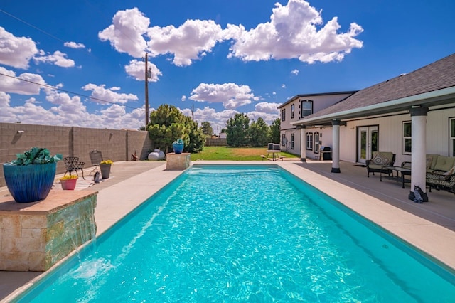 view of swimming pool featuring pool water feature and a patio