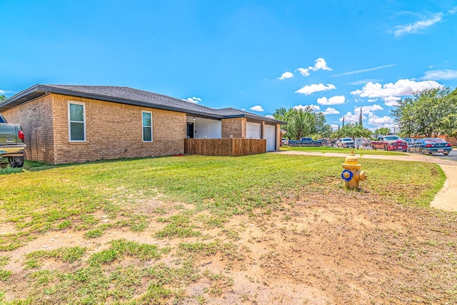 1604 Mcdonald St, Midland, TX 79703 - view of side of property with brick siding, an attached garage, driveway, and a yard