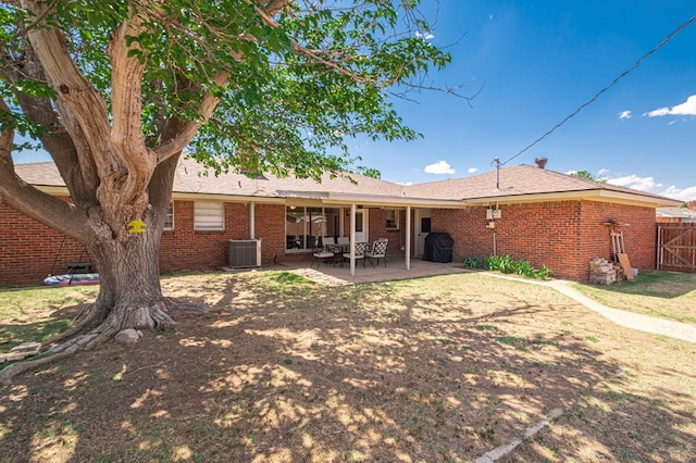 back of house featuring fence, brick siding, central AC unit, a gate, and a patio area