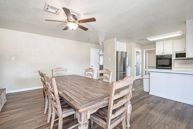 dining room with visible vents, a ceiling fan, a textured ceiling, and dark wood-style floors