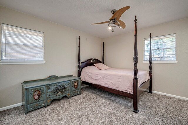 bedroom with light colored carpet, baseboards, and ceiling fan