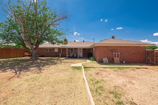 rear view of property featuring fence, central AC, a patio area, and brick siding