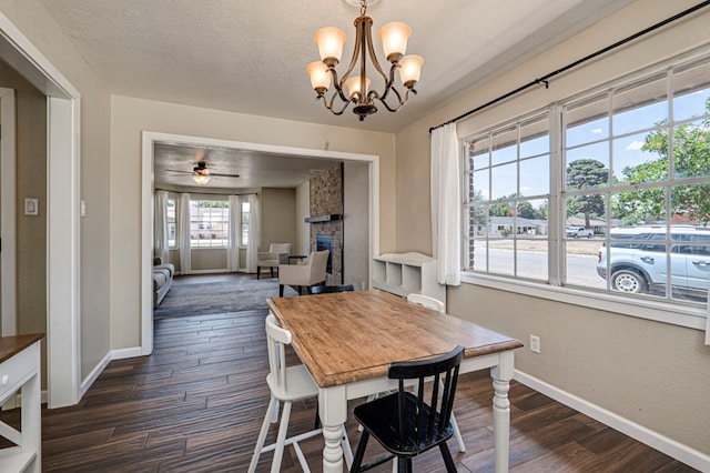 dining area with baseboards, dark wood finished floors, ceiling fan with notable chandelier, and a fireplace