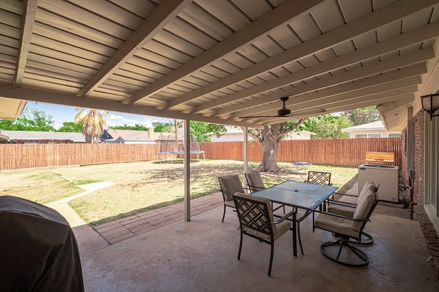 view of patio featuring a fenced backyard, a trampoline, area for grilling, and outdoor dining space