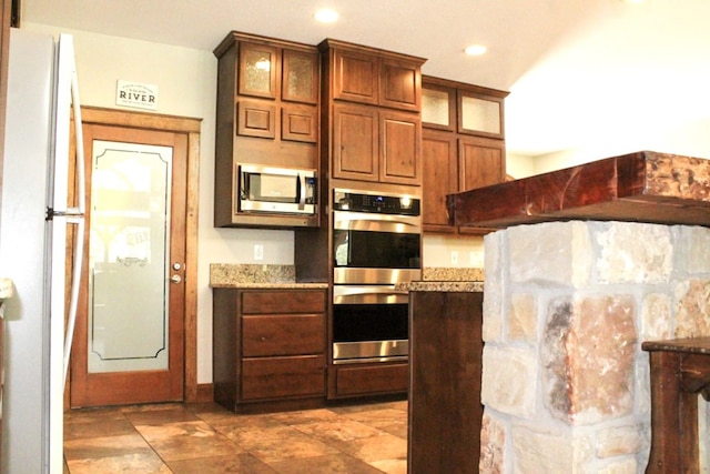 kitchen featuring light stone counters and appliances with stainless steel finishes