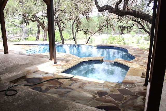 view of pool with an in ground hot tub