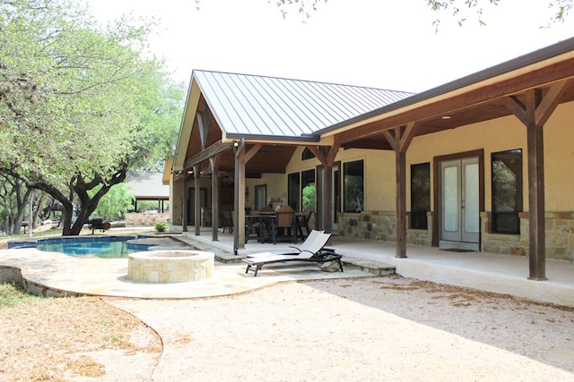 back of property with a patio area and an outdoor fire pit