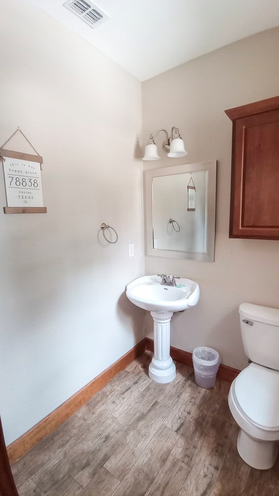 bathroom featuring hardwood / wood-style flooring and toilet