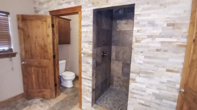 bathroom with tiled shower and toilet