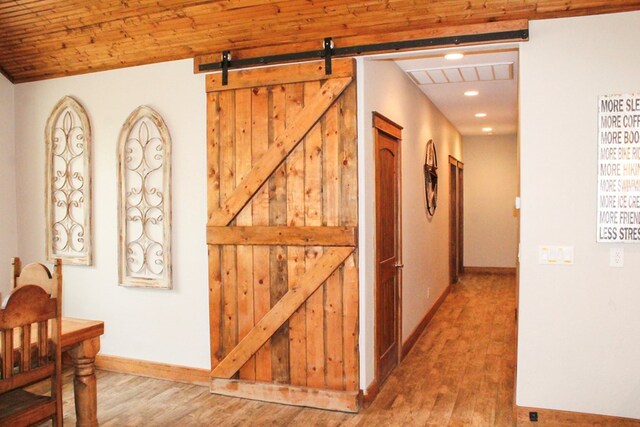 hallway featuring hardwood / wood-style floors, a barn door, and wooden ceiling