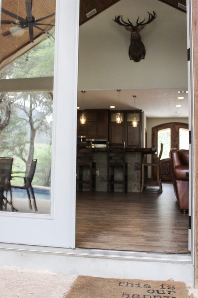 interior space featuring ceiling fan, wood-type flooring, and high vaulted ceiling