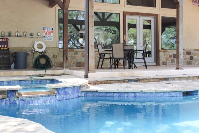 view of swimming pool with a patio area, an in ground hot tub, and pool water feature