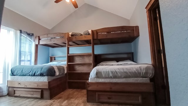 bedroom featuring ceiling fan, lofted ceiling, and light wood-type flooring