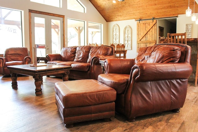 living room with hardwood / wood-style floors, wooden ceiling, high vaulted ceiling, french doors, and a barn door