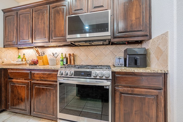 kitchen with dark brown cabinetry, appliances with stainless steel finishes, and decorative backsplash