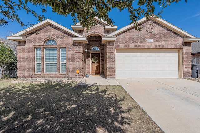 view of front of home with a garage, driveway, and brick siding