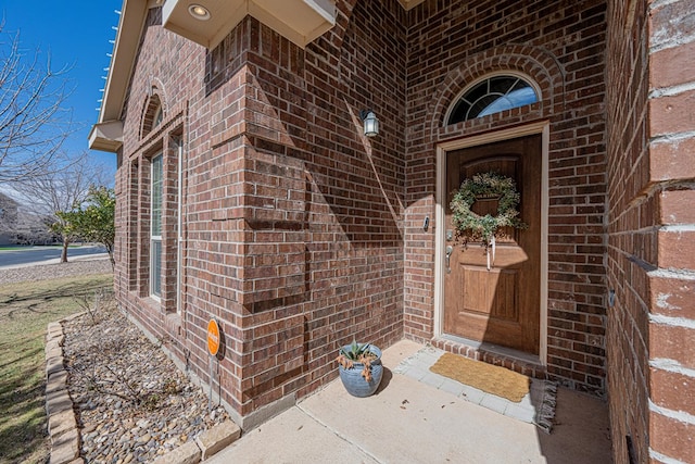 doorway to property featuring brick siding