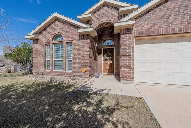 view of front of home featuring a garage and brick siding