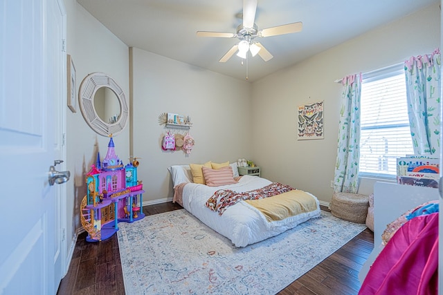 bedroom with a ceiling fan, baseboards, and wood finished floors