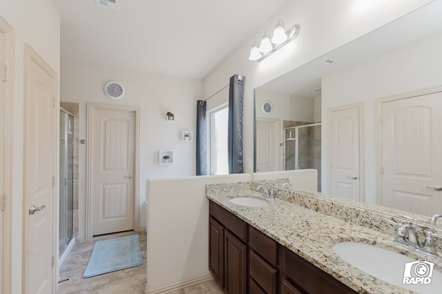 full bath featuring visible vents, a sink, a shower stall, and double vanity