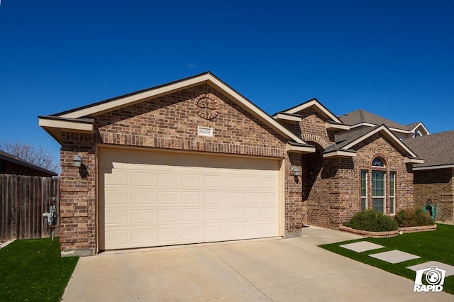 ranch-style house with a garage, brick siding, driveway, and fence