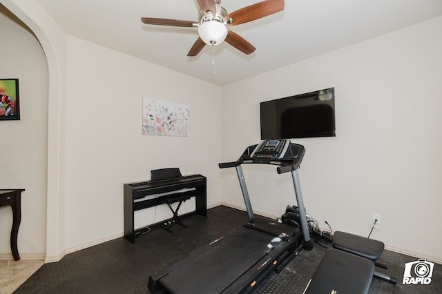 workout area featuring ceiling fan and baseboards