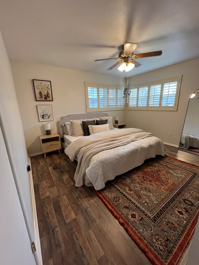 bedroom featuring dark wood-type flooring, ceiling fan, and multiple windows