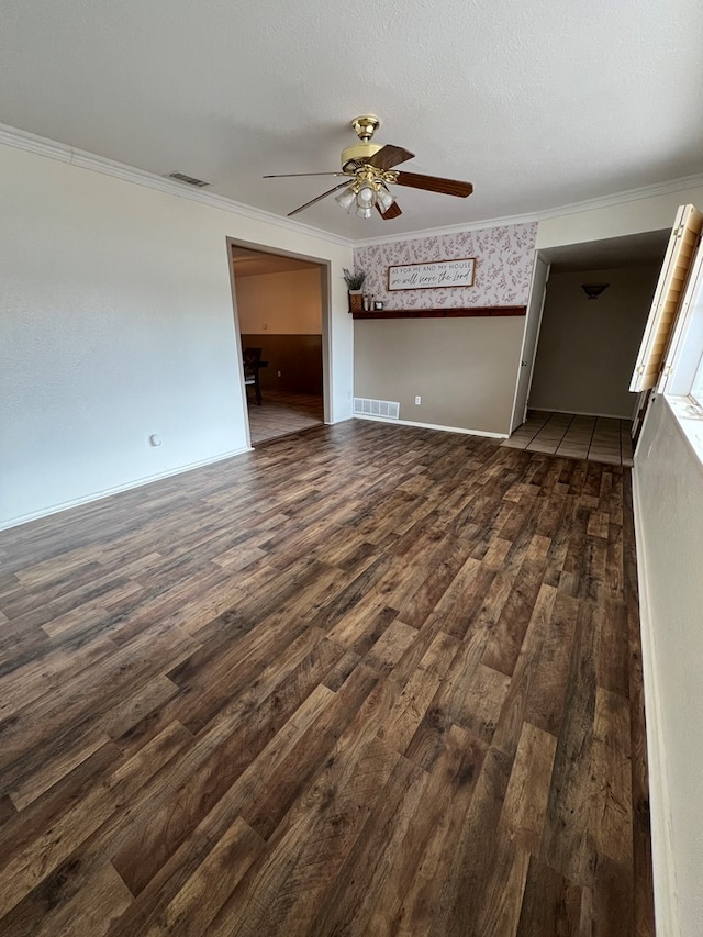 unfurnished living room featuring ornamental molding, dark hardwood / wood-style floors, a textured ceiling, and ceiling fan