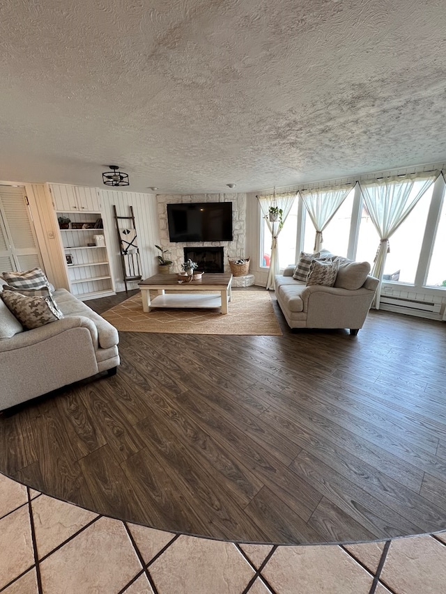 unfurnished living room featuring baseboard heating, hardwood / wood-style floors, and a textured ceiling