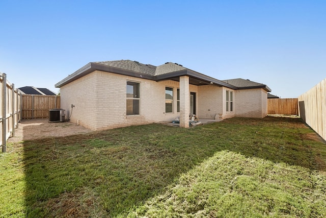 rear view of property with a yard and central AC