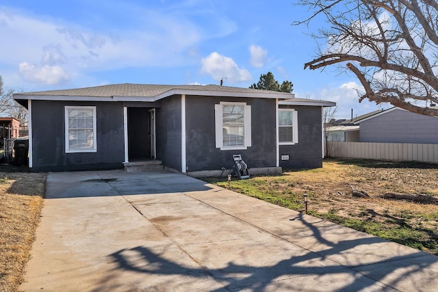 1105 Lamar Ave, Big Spring, TX 79720 - view of front of house featuring driveway, fence, and concrete block siding