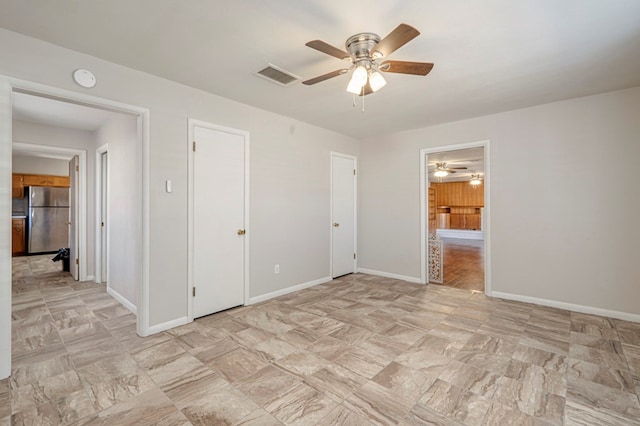 unfurnished bedroom with ensuite bath, stainless steel fridge, and ceiling fan