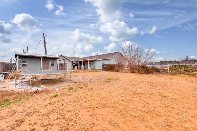 rear view of house featuring a trampoline