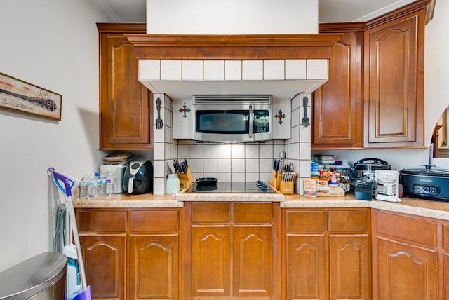 kitchen featuring tasteful backsplash, black electric stovetop, and crown molding