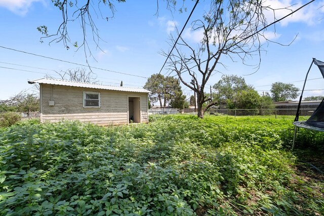 1213 Ridgeroad Dr, Big Spring, TX 79720 - view of yard with a trampoline and an outbuilding