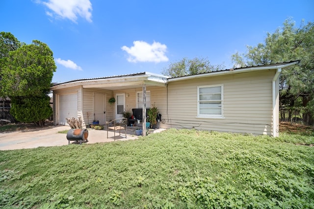 1213 Ridgeroad Dr, Big Spring, TX 79720 - rear view of house featuring a garage, concrete driveway, and a yard