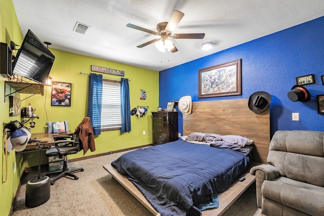 carpeted bedroom with ceiling fan and a textured ceiling