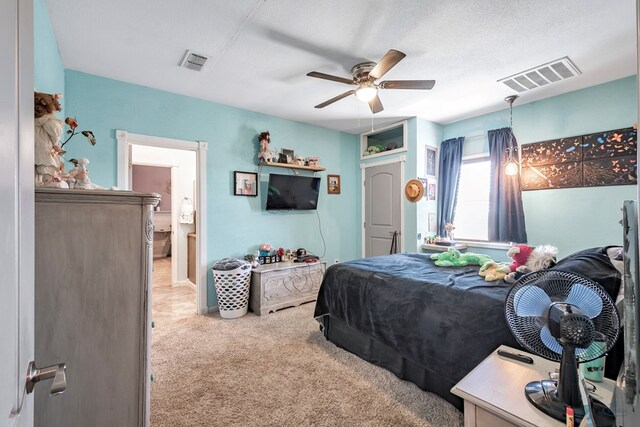 carpeted bedroom featuring ceiling fan and a textured ceiling
