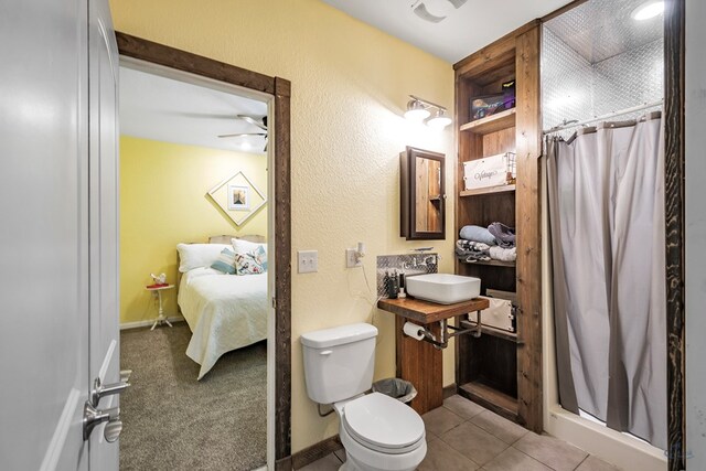 bathroom featuring tile patterned floors, sink, ceiling fan, toilet, and walk in shower