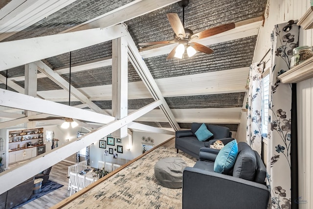 living room with beamed ceiling, ceiling fan, wood-type flooring, and high vaulted ceiling
