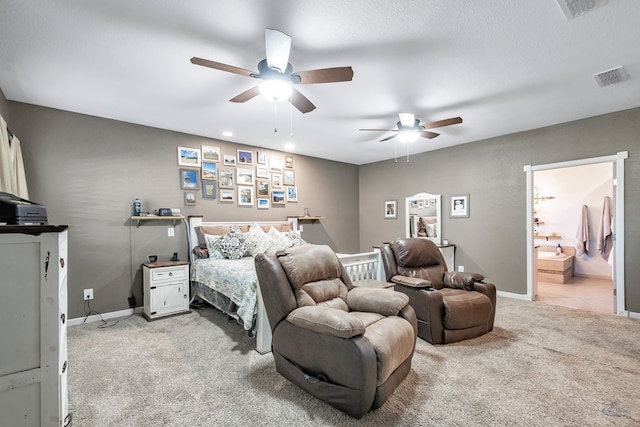 carpeted bedroom with a textured ceiling, ensuite bathroom, and ceiling fan