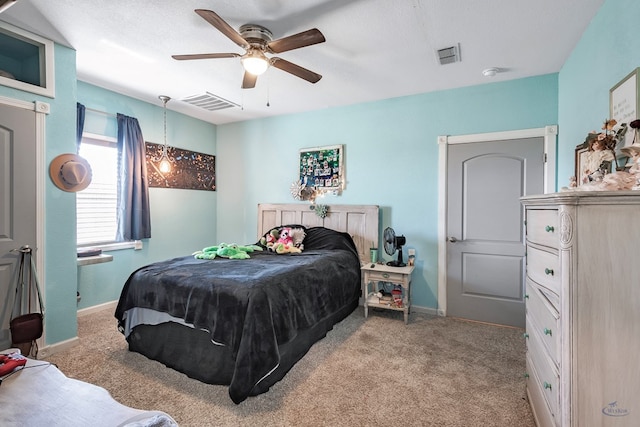 carpeted bedroom with a textured ceiling and ceiling fan