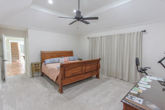 bedroom featuring a raised ceiling, light carpet, and ceiling fan