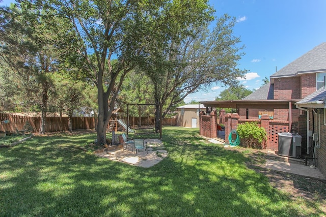 view of yard with a playground, a patio, central AC unit, and a shed